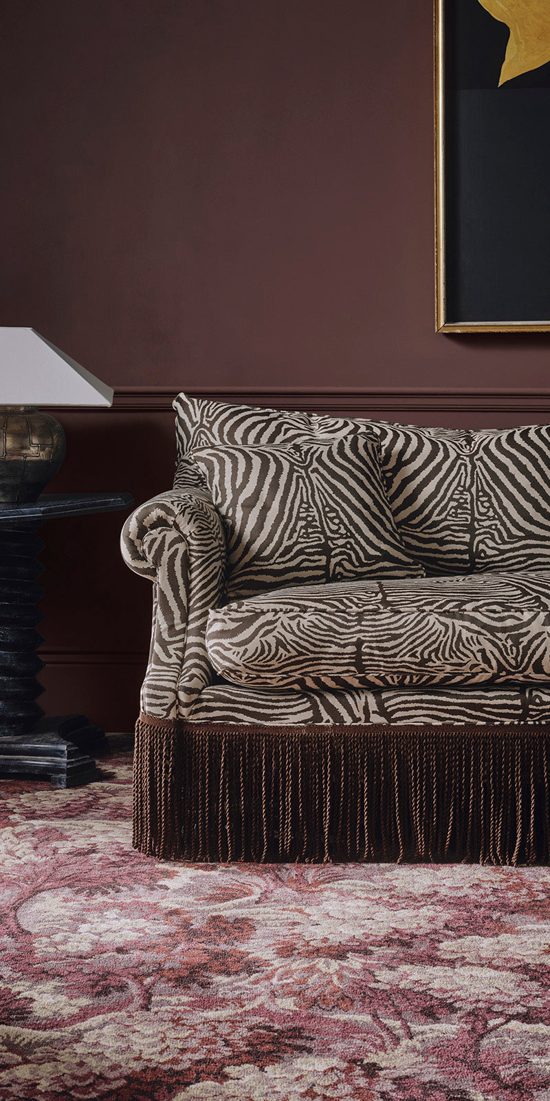 a couch with a zebra print and a lamp on a table