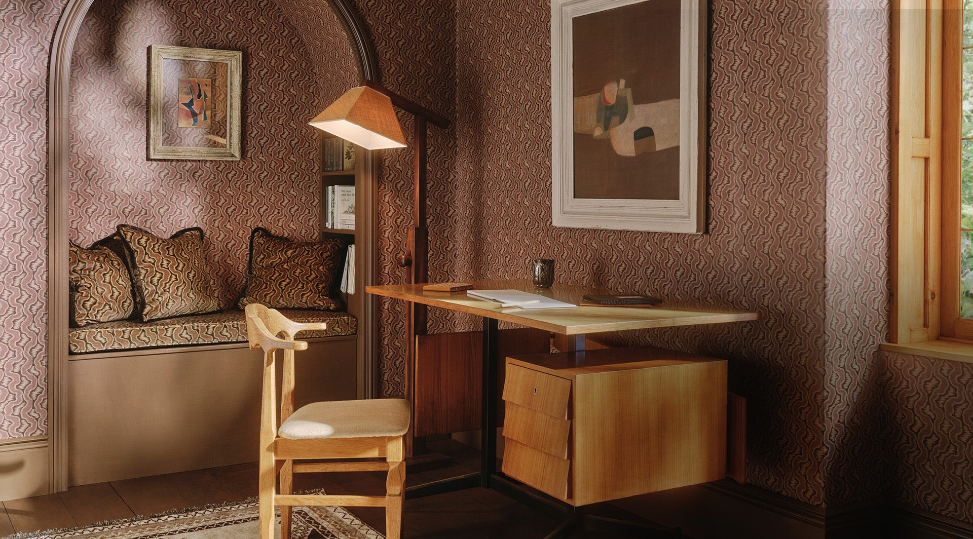 a desk with a lamp and a painting on the wall