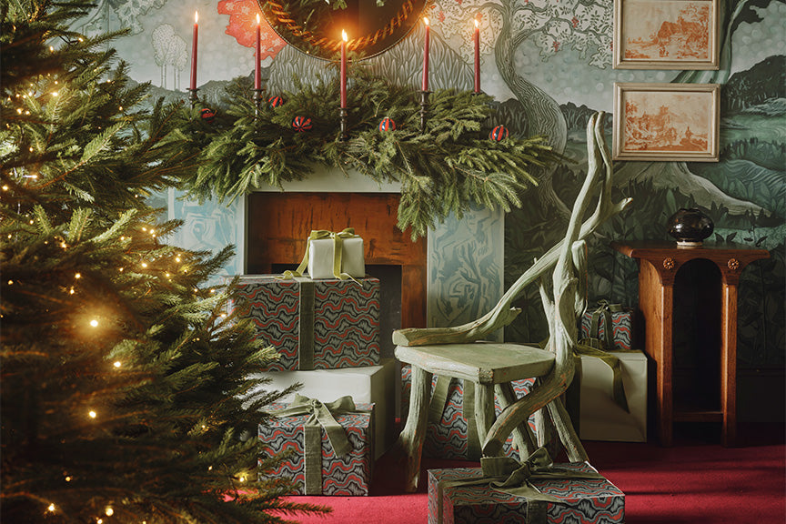 a christmas tree with presents and a chair