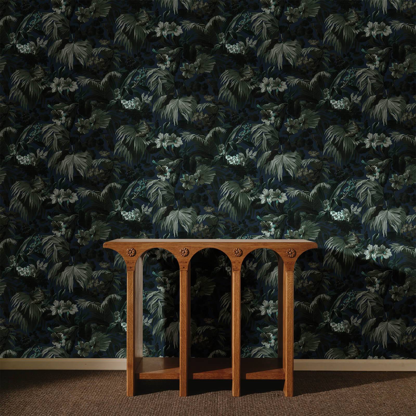 a wooden table in front of a wall with a floral wallpaper