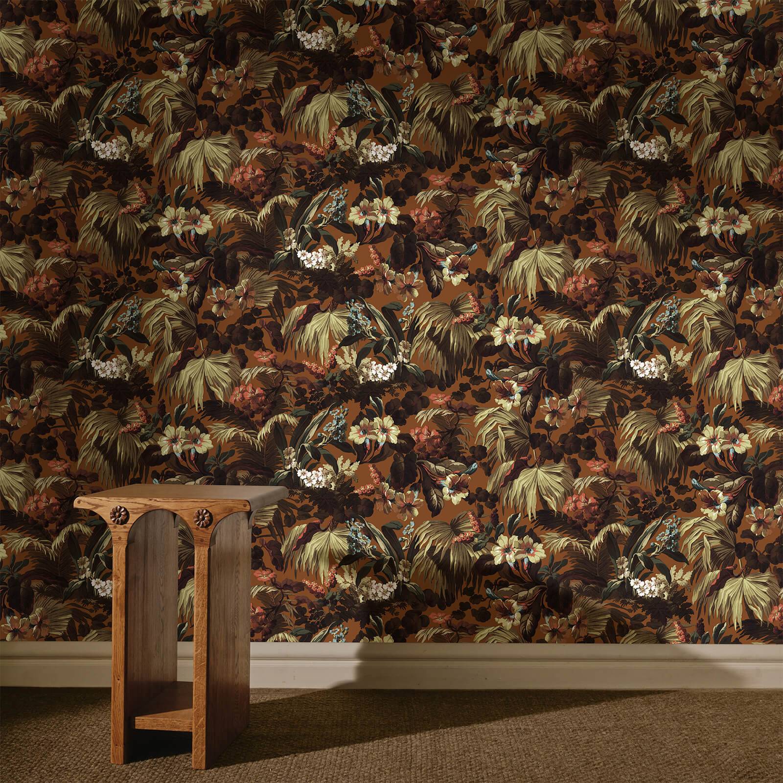 a wooden table in front of a floral wallpaper
