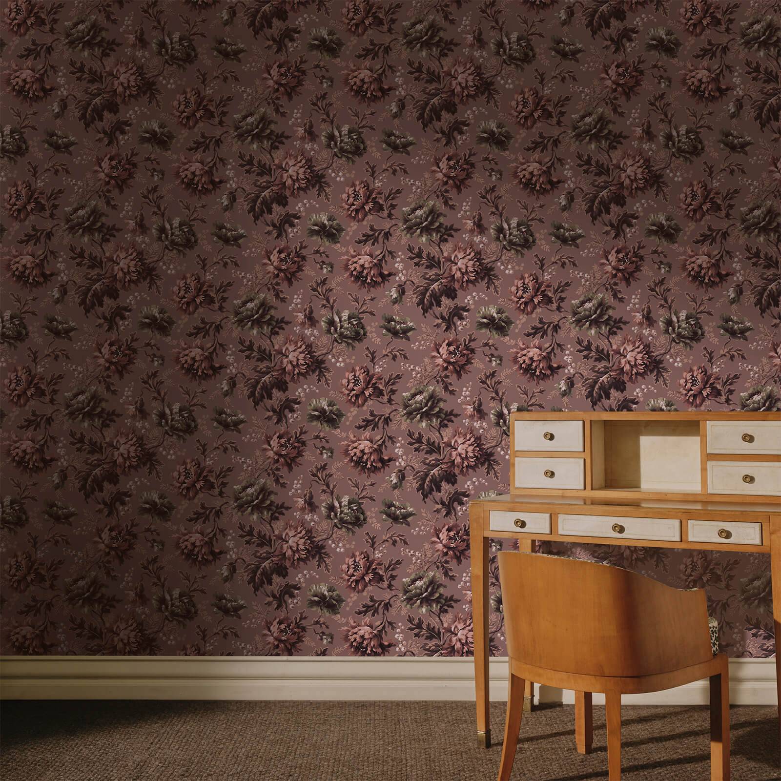 a desk and chair in a room with floral wallpaper