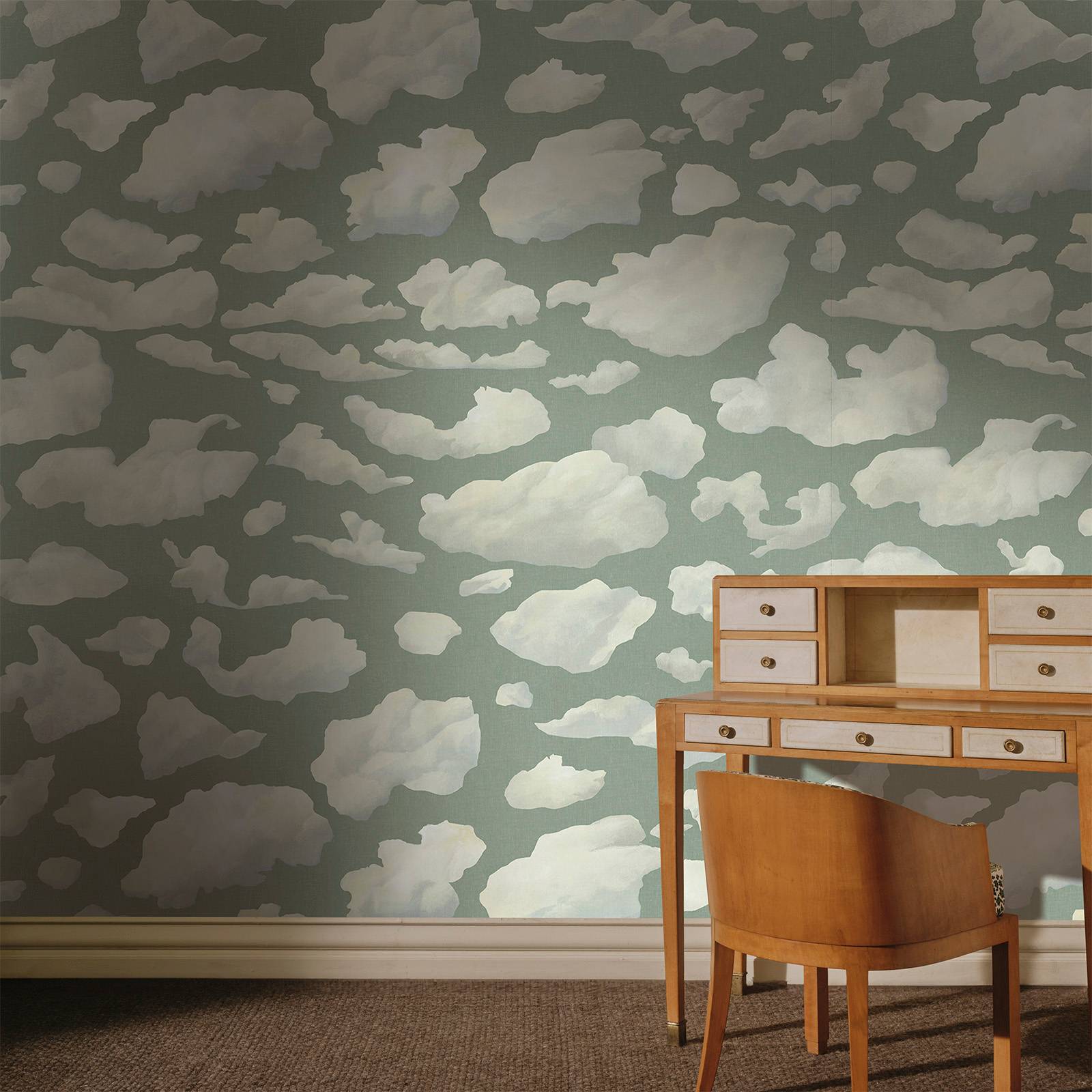 a desk and chair in a room with clouds wallpaper