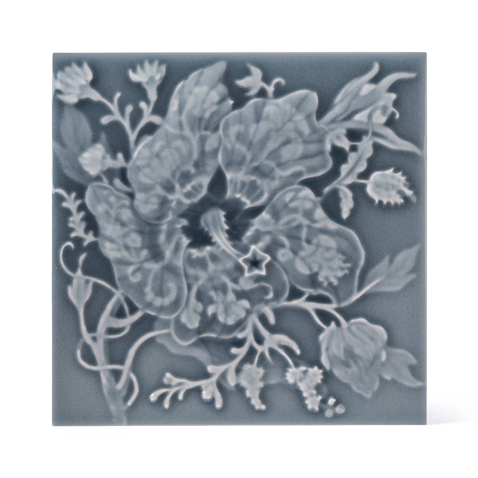 a grey tile with a flower design